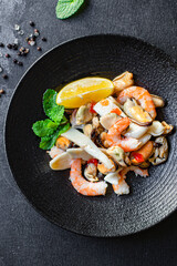 seafood salad assortment appetizer shrimp, mussels, squid and other healthy meal snack on the table top view copy space for text food background rustic pescetarian diet