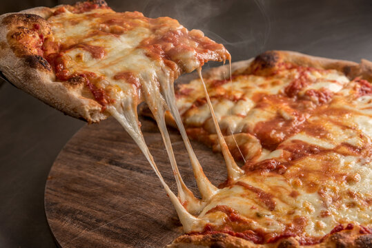 slice of pizza with tomato sauce and with hot cheese spinning mozzarella