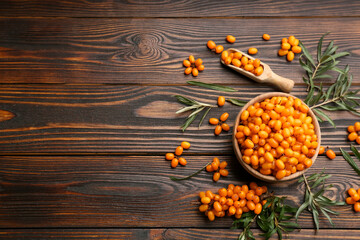 Fresh ripe sea buckthorn on wooden table, flat lay. Space for text