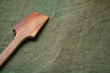 The wooden spatula lie on a green ragcloth