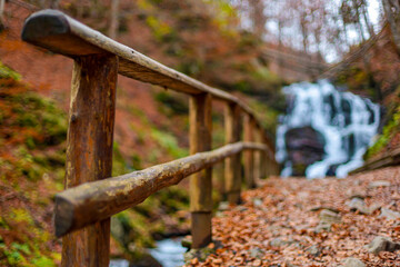 waterfall in the autumn forest with authentic wooden handrails. wallpaper, screensaver, poster wallpaper, screensaver, poster
