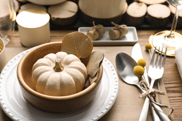 Autumn table setting with pumpkin and decor on wooden background