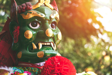 Low angle and close up face of traditional green Chinese god statue (Favourable -wind Ear) with...