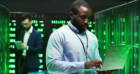 Portrait of handsome African American young man cryptograph standing in big data storage and...