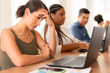 Fototapeta premium In pain business woman stressed with work, suffering headache in business cowork space. burnout syndrome, stress, pressure concept..