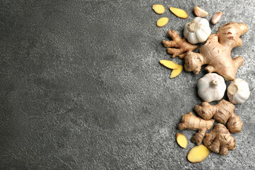 Flat lay composition with ginger, fresh garlic and space for text on grey table. Natural cold...