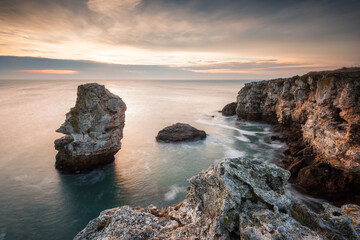 Fototapeta na wymiar Magnificent sea sunrise at the rocky Black sea coast with a lonely rock in the sea