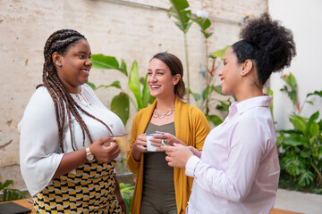 Brazilian business leader talking causally with co-workers.outside in the garden. Candid, connection, break, relaxation, chatting concept..