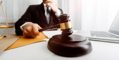 Justice and law concept.Male judge in a courtroom with the gavel, working with, computer and...