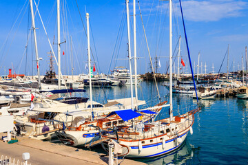 Fototapeta na wymiar White yachts in the sea harbor of Kemer, Antalya province in Turkey. Kemer Marina on the Mediterranean sea