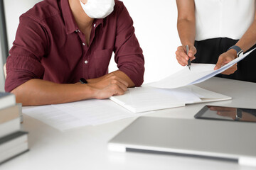 University students brainstorming on assignments using tablet and laptop at library.