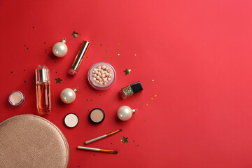 Flat lay composition with decorative cosmetic products on red background, space for text. Winter care
