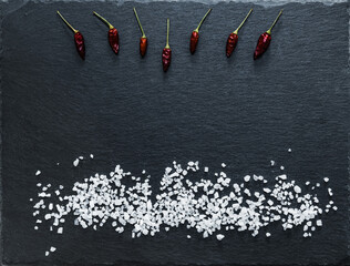 red peppers and salt on a black background