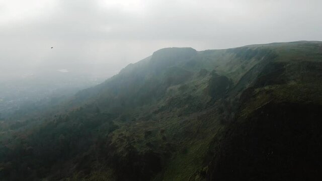 Rotating aerial view of Cavehill, Belfast in foggy conditions