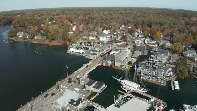 River across downtown with two-masted sailboat and bridge, drone shot, Kennebunkport ME