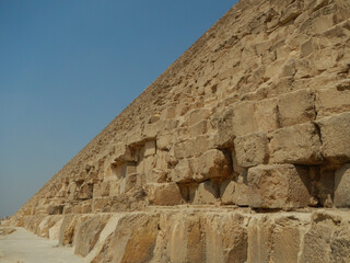 Fototapeta na wymiar Stone wall of the Egyptian pyramid against the sky