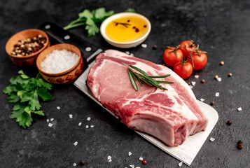 
raw steak on a knife with spices on a stone background