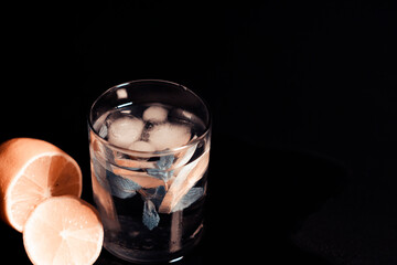 On the left side of the screen are a glass of water, ice cubes, a sprig of mint and a slice of lemon. Next to a sliced lemon.