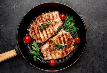 grilled pork steaks in a grill pan with spices

