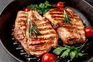 grilled pork steaks in a grill pan with spices

