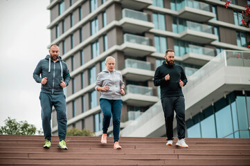 Three young friends running on the steps
