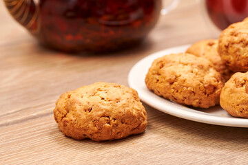 Hot aroma tea set teapot, cup of tea and little cookie on wooden table