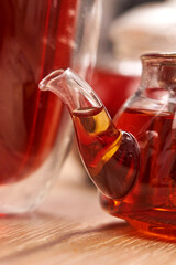 Close-up a hot tea in transparent glass teapot on the table with reflection.