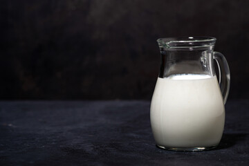 jug with fresh milk on a black background