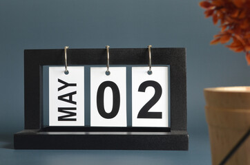 May 2, Date design with a black wooden calendar for a business, Date Plans to remind.