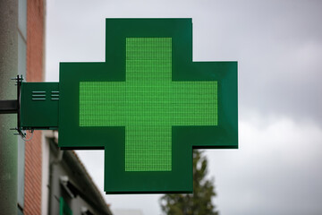 Green cross hanging outside drugstore