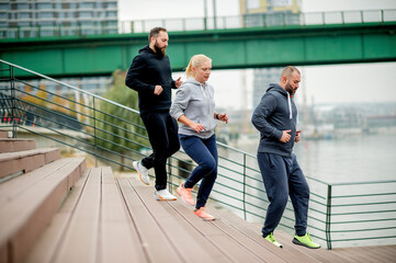 Three young friends running on the steps