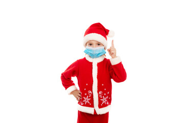 Little boy in a costume of Santa Claus and in a medical mask raised his index stick up