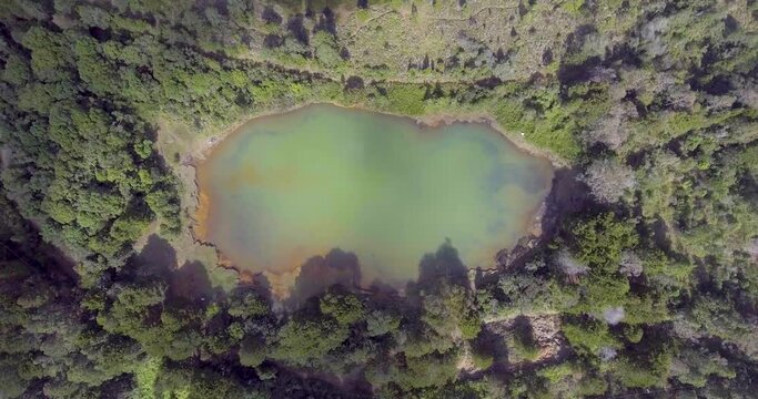 Pristine Green Guarne Lagoon in the Middle of the Woods near Medellin, Colombia on a Cloudy Day shot from in Smooth Travelling form Above