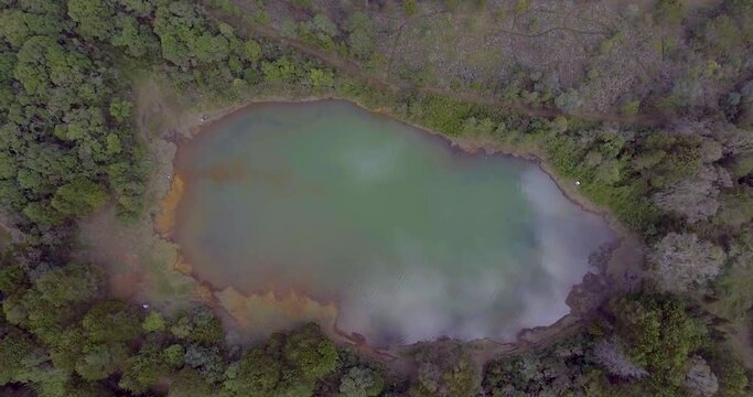 Pristine Green Guarne Lagoon in the Middle of the Woods near Medellin, Colombia on a Cloudy Day shot from in Smooth Travelling form Above