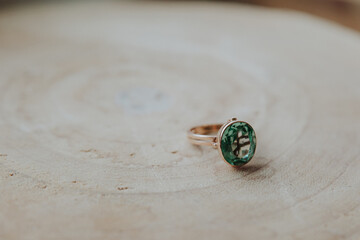 ring with green stone standing on wood floor, ruby stone