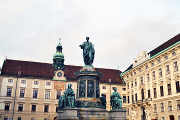 Fototapeta na wymiar Famous Hofburg palace in Vienna, Austria. A sculptural composition in the center. Latin inscription 