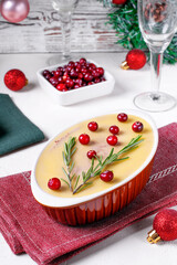 Chicken liver pate with butter topped with cranberry and rosemary served in the ceramic dish on the...