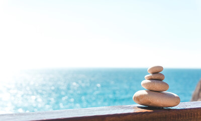 Zen relax background. A pyramid of stones on the beach in clear sunny weather. Background for meditation, yoga and massage