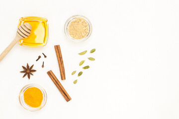 Honey and cardamom, cinnamon sticks. Dry ginger and turmeric in glass bowl.