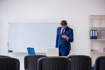 Fototapeta premium Young male business trainer in the office during pandemic