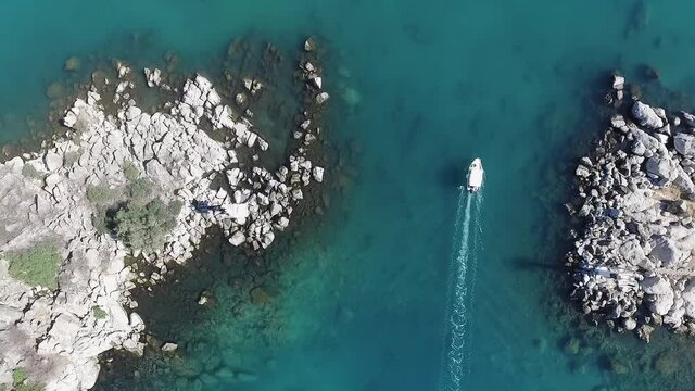 Aerial overhead view of boat exiting Methana harbour, Greece