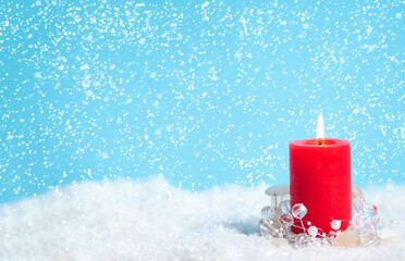Christmas card with red candle and snow with xmas and new year holiday decoration on the blue background