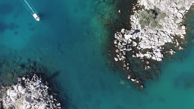 Aerial overhead view of boat exiting Methana harbour, Greece