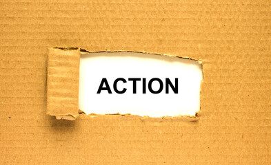 The word Action appearing behind torn brown paper