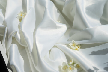 Fototapeta na wymiar White silk fabric and flowers