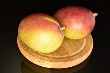 ripe organic mango, close-up, on a black background.