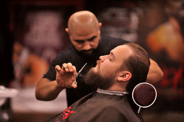 Brutal barber shaves a man in a barbershop