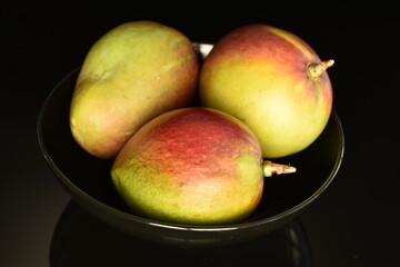 ripe organic mango, close-up, on a black background.