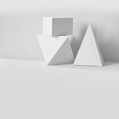 Platonic solids figures geometry. Abstract white color geometrical objects still life composition. Three-dimensional prism pyramid rectangular cube on gray background