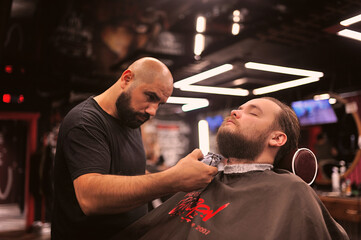 Brutal barber shaves a man in a barbershop